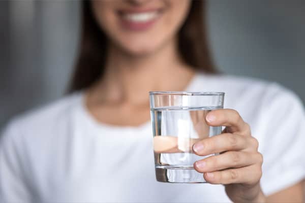 Mujer sujetando un vaso de agua