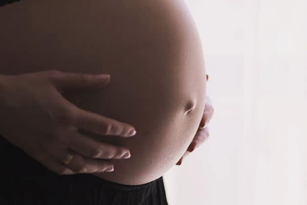 Mujer embarazada con las manos en el vientre