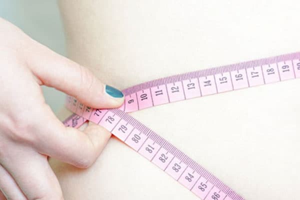 Mujer midiéndose la cintura