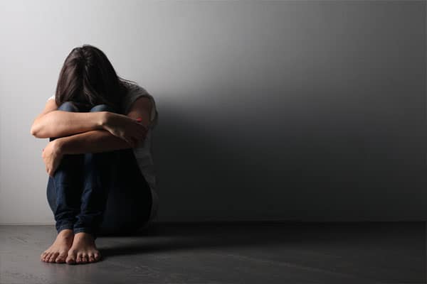Mujer encogida debido a la depresión y soledad