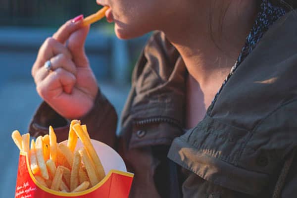 Persona comiéndose unas patatas fritas