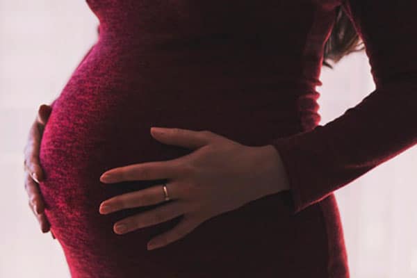 Mujer embarazada con las manos en la barriga