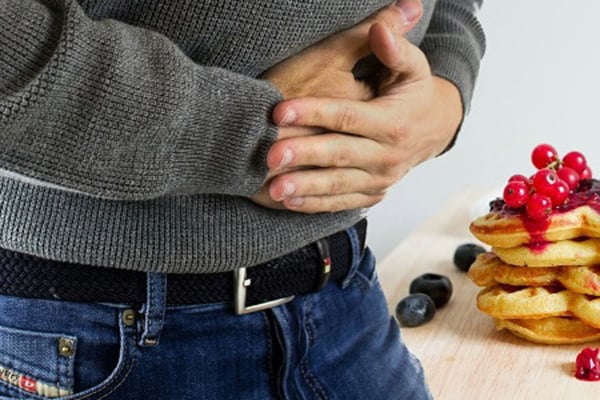 Persona cogiéndose el estomago debido a la inflamación