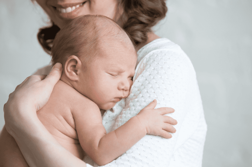 Fertilidad funcional: Mujer sostiene en sus brazos a su bebé recién nacido