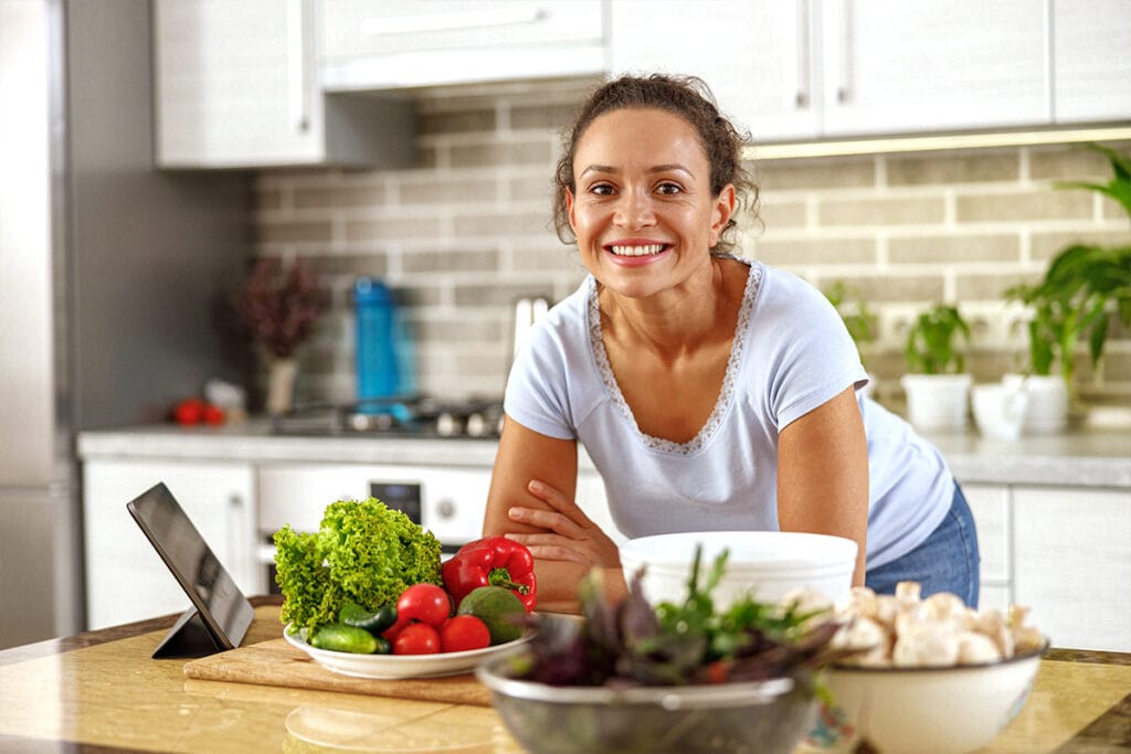 Una mujer con menopausia prepara alimentos recomendados durante la menopausia