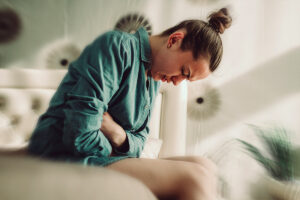 Una chica tiene dolores y síntomas del síndrome premenstrual