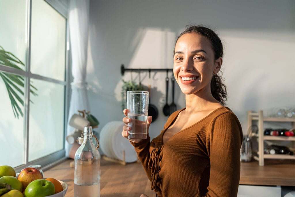 Una mujer bebiendo agua, la principal bebida permitida durante el ayuno intermitente