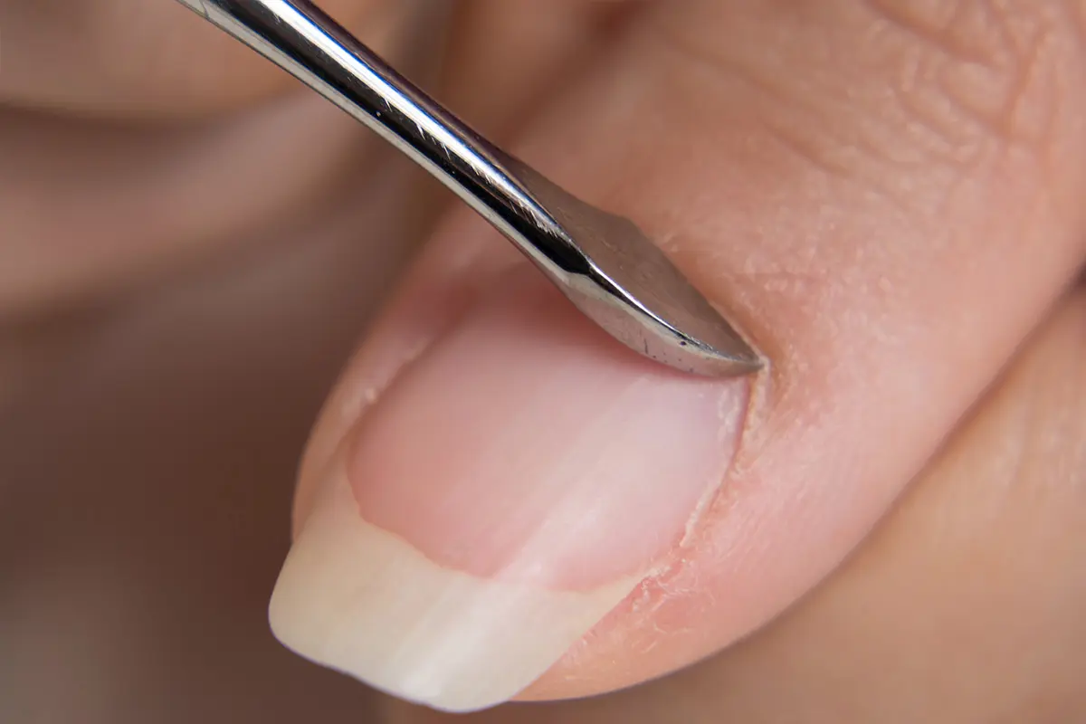 Una chica con rayas en las uñas verticales tras la manicura