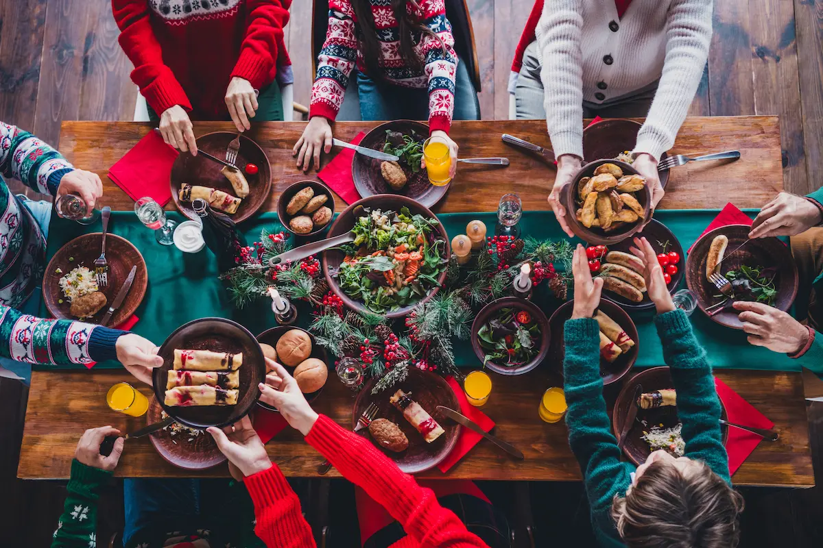 Mesa de Navidad llena de platos típicos como carnes, dulces y salsas, que pueden causar digestiones pesadas sin ayuda de enzimas digestivas.